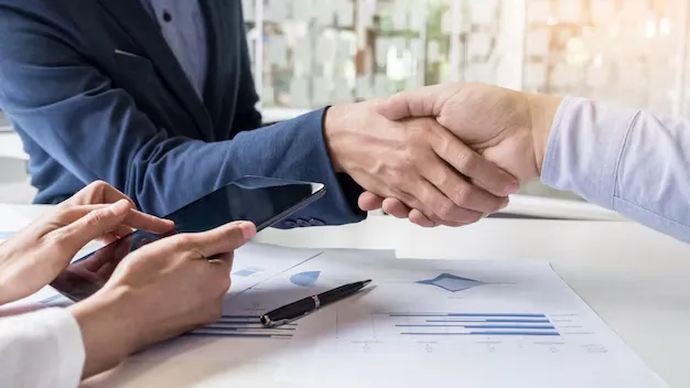 Dos empresarios locales de Murcia cerrando un acuerdo de colaboración estratégica con un apretón de manos